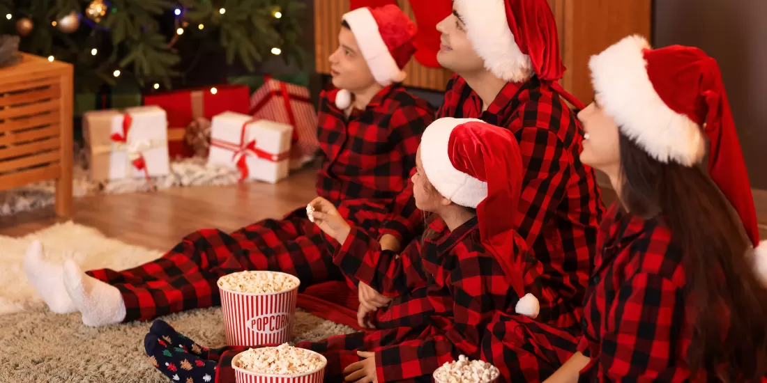 family watching a movie in Christmas pajamas
