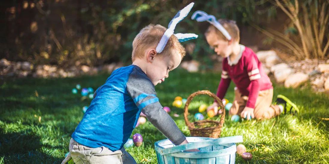Kids in bunny headbands collecting easter eggs