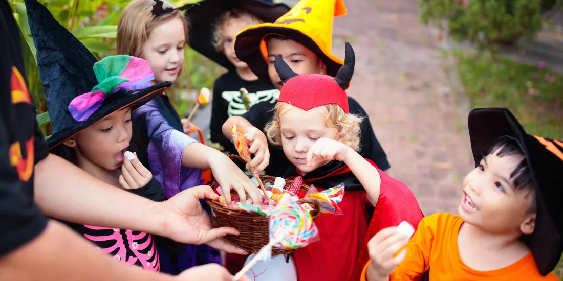 Children picking halloween candy from a basket