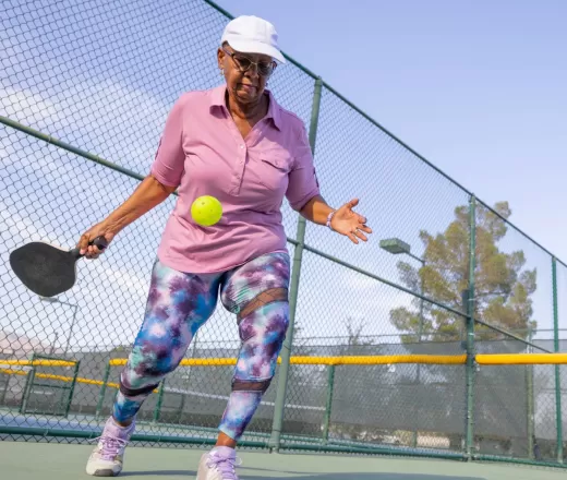 Woman outside playing pickleball
