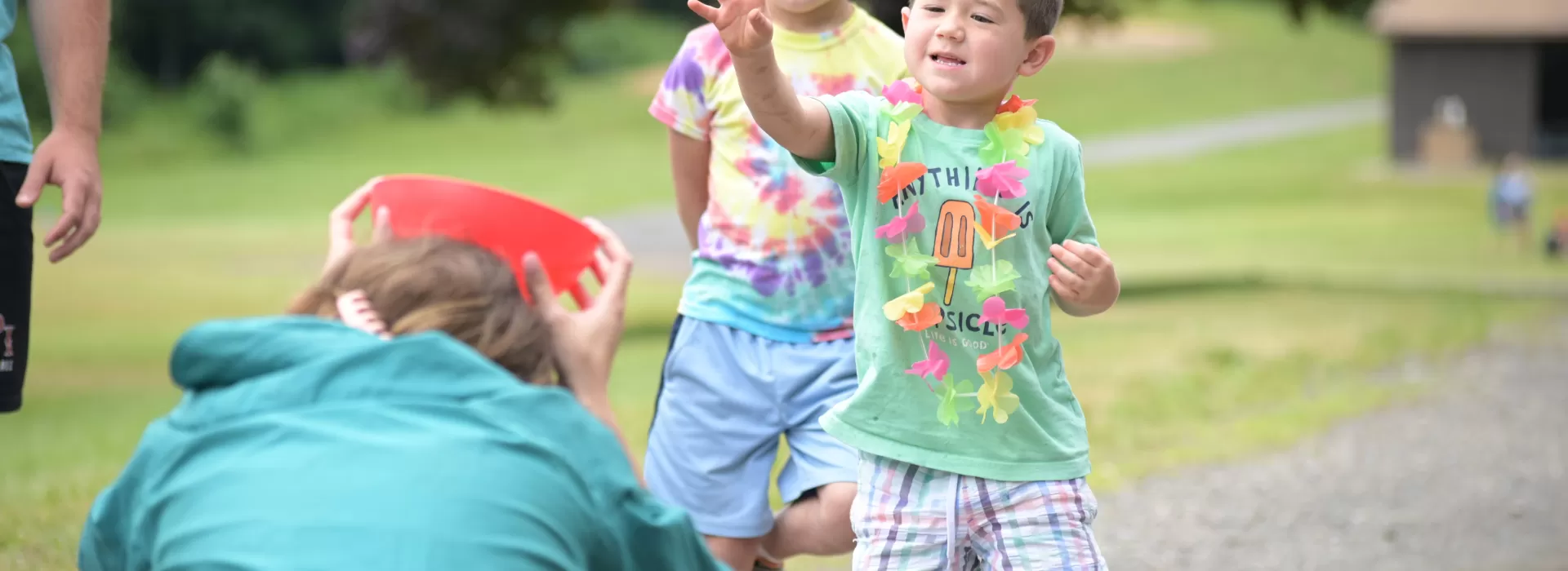boy throwing ball into cup